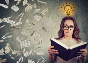 Woman student reading a book has a bright idea how to earn money
